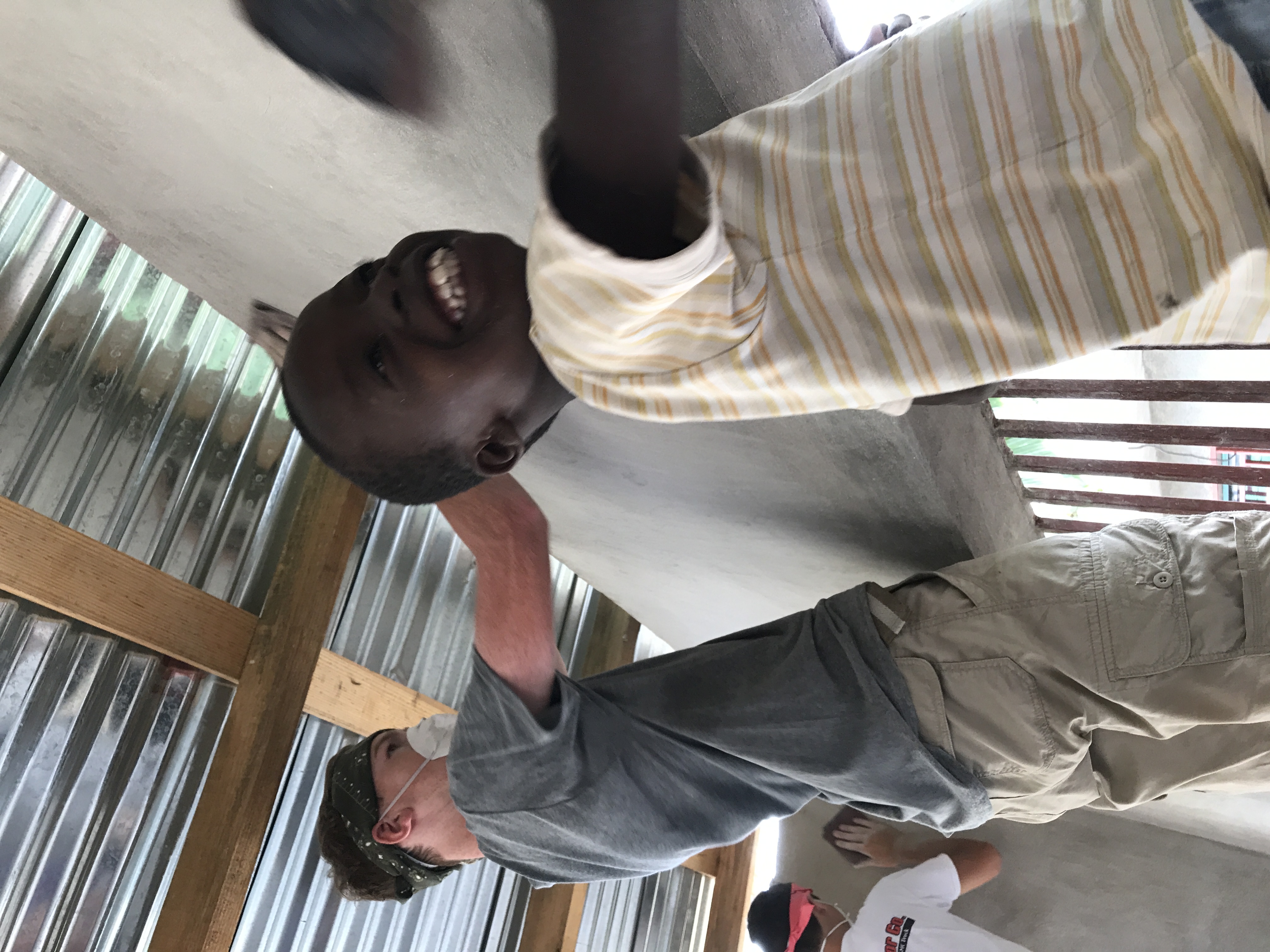 Team members painting a school building in Jacmel
